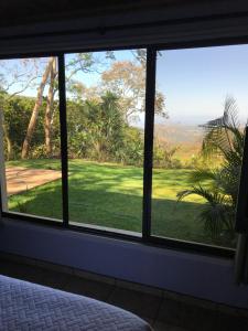 ventana del dormitorio con vistas a un campo de golf en Villa Magallanes, en San Ramón