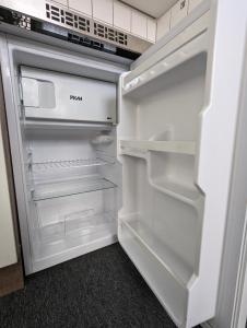 een lege koelkast met de deur open in een keuken bij City Apartment & Lift - Hoeft in Wuppertal