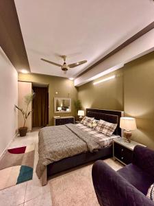 um quarto com uma cama grande e um sofá em Islamabad Oasis Residences em Islamabad