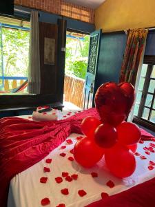 a bed with a bunch of red balloons on it at Pousada Lua Bonita in Nova Lima