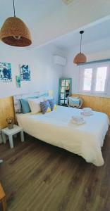 ein großes weißes Bett in einem Schlafzimmer mit Holzböden in der Unterkunft DORIS Beach House. Praia Furadouro .Ovar.Aveiro in Furadouro