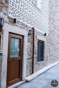 een deur aan de zijkant van een bakstenen gebouw bij SKINOS rooms and apartment in Pyrgi