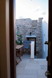 eine Terrasse mit einem Tisch und einem Kamin in der Unterkunft SKINOS rooms and apartment in Pyrgi