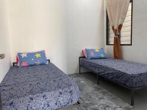 - une chambre avec 2 lits et une fenêtre dans l'établissement Rumah 2029, à Masjid Tanah