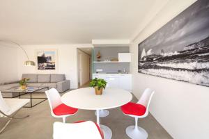 a living room with a white table and red chairs at La Savina Dream in La Savina +7 photos