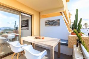 a dining room with a table and white chairs at La Savina Dream in La Savina