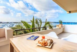 a table with a plate of food on a balcony at La Savina Dream in La Savina