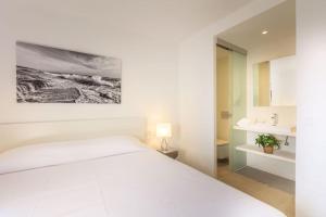 a bedroom with a white bed and a bathroom at La Savina Dream in La Savina