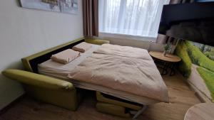 a small bed in a small room with a window at Lesíček in Smokovce