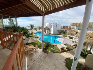 uma vista para a piscina a partir da varanda de um resort em Hotel Beso de Sal Resort em Colán