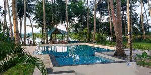 uma piscina com um gazebo e palmeiras em Ocean Pearl Beach Resort, Havelock em Ilha Havelock
