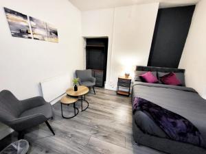 a bedroom with a bed and a table and a chair at Stay Sleep Rest - Grove Haven in Hull