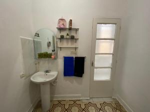 a white bathroom with a sink and a mirror at Chez khaleed in Rabat