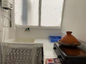 a bathroom with a bath tub and a window at Chez khaleed in Rabat