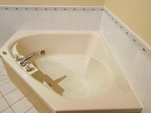 a white bath tub with a faucet in a bathroom at Ceilidh Country Lodge in Baddeck +28 photos