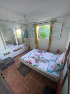 1 dormitorio con 1 cama grande y 2 ventanas en Un été sans fin, en Le Marin