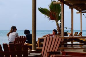 un grupo de personas sentadas en una mesa en la playa en Hostel Santa Cruz del Islote, en Santa Cruz del Islote