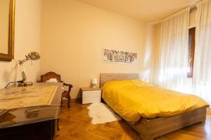 a bedroom with a yellow bed and a desk at Casa Gozza in Verzuolo