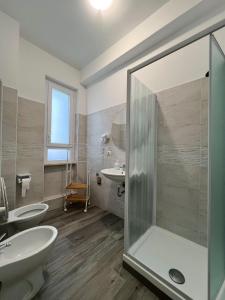 een badkamer met een douche, een toilet en een wastafel bij B&B Rifugio San Francesco in Lido di Ostia