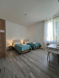 ein Schlafzimmer mit 2 Betten und einem Tisch darin in der Unterkunft B&B Rifugio San Francesco in Lido di Ostia