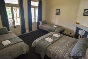 um quarto de hotel com três camas e uma lareira em Junee Hotel em Junee