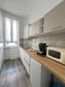 a kitchen with white cabinets and a microwave on a counter at B&B Rifugio San Francesco in Lido di Ostia