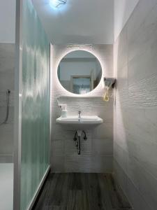 La salle de bains est pourvue d'un lavabo et d'un miroir. dans l'établissement B&B Rifugio San Francesco, à Lido di Ostia