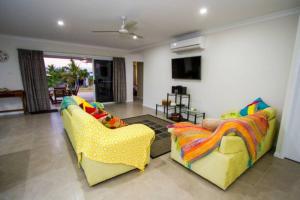 a living room with two yellow couches at Seas The Day - Pet-friendly house in Agnes Water in Agnes Water