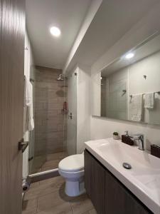 y baño con aseo, lavabo y ducha. en Espectacular apartamento en Barranquilla, en Puerto Colombia