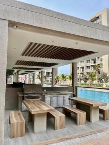 un patio con 2 bancos de madera y una parrilla en Espectacular apartamento en Barranquilla, en Puerto Colombia