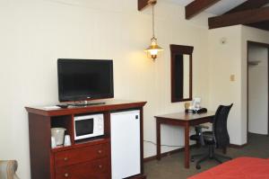 a room with a desk with a microwave and a television at Tea Island Resort in Lake George