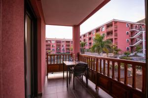a balcony with a table and chairs and a building at Ninel Home Tenerife in Palm-mar