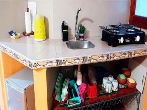 un piano di lavoro con lavandino e utensili da cucina di Ipay Alojamiento Familiar a Purmamarca