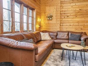 a living room with a leather couch and a table at 8 person holiday home in Ringk bing in Ringkøbing