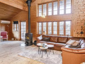 a living room with a leather couch and a fireplace at 8 person holiday home in Ringk bing in Ringkøbing