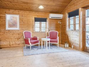リンケビングにある8 person holiday home in Ringk bingの木製の壁の部屋(椅子2脚、テーブル1台付)