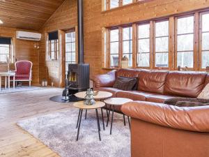 a living room with a leather couch and a fireplace at 8 person holiday home in Ringk bing in Ringkøbing