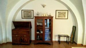 Habitación con armario de madera y mesa. en Residenza Le Volte Degli Angeli, en Spello