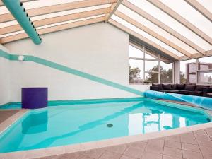 a swimming pool in a house with a ceiling at 8 person holiday home in Knebel in Knebel