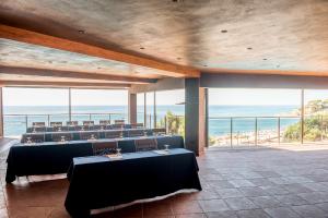 a room with tables and chairs with a view of the ocean at Rigat Park & Spa Hotel - Adults Recommended in Lloret de Mar