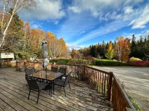 a table and chairs on a wooden deck with an umbrella at Eden Estate B&B in Reidville