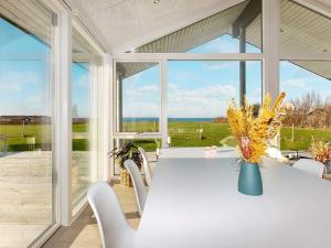 comedor con mesa, sillas y ventanas en Holiday home Vinderup XXIX, en Vinderup