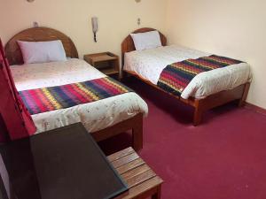 a room with two beds and a laptop on a table at HOSTAl HUAYNA HOUSE in Cusco
