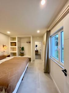 - une chambre avec un grand lit et une fenêtre dans l'établissement Sunday Morning Guesthouse, à Aljezur