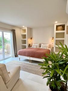 a bedroom with a bed and a large window at Sunday Morning Guesthouse in Aljezur