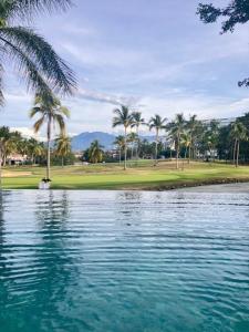 un bacino idrico con palme e un campo da golf di Casa Cielo Vallarta V-Golf a Puerto Vallarta