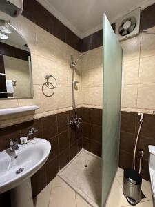 Sedrah Al Aziziah Hotel 2 في Al ‘Azīzīyah: حمام مع دش ومغسلة ومغسلة