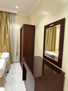 Sedrah Al Aziziah Hotel 2 في Al ‘Azīzīyah: غرفة في الفندق مع مرآة وسرير