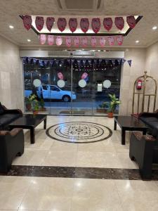 Sedrah Al Aziziah Hotel 2 في Al ‘Azīzīyah: لوبي بطاولات وسيارة في شباك