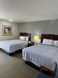 una habitación de hotel con 2 camas y una lámpara en Budget Inn Motel, en Storm Lake